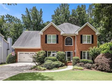 Charming brick two-story home featuring a well-manicured lawn and attached two-car garage at 1884 Whitehawk Ct, Lawrenceville, GA 30043