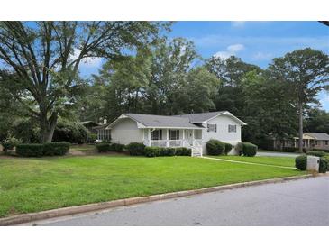 Charming home with a well-manicured lawn and inviting front porch, perfect for relaxing outdoors at 3835 Clearwater Dr, Atlanta, GA 30349