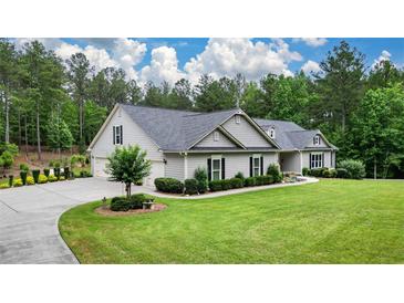 Charming single-story home with manicured lawn, lush landscaping, and an expansive driveway at 188 Macedonia Rd, White, GA 30184