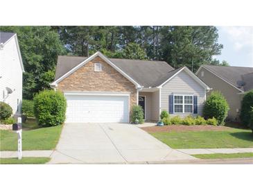 Charming one-story home with stone accents, a two-car garage, and a well-manicured lawn at 414 Norton Xing, Woodstock, GA 30188