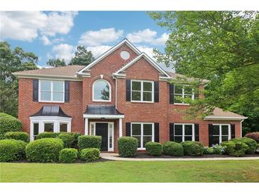 Charming two-story brick home with manicured lawn, black shutters, and mature landscaping at 9744 Spyglass Dr, Villa Rica, GA 30180