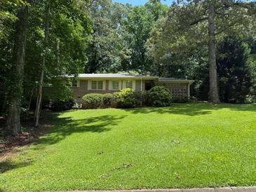 Charming single-story home featuring a brick facade and lush green landscaping at 2990 Piedmont Dr, Marietta, GA 30066
