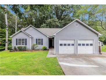 Charming home featuring a well-maintained front yard, two-car garage, and classic curb appeal at 112 Laguna Springs Dr, Woodstock, GA 30188