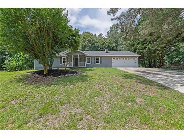 Charming single-story home with a well-maintained lawn, classic gray siding, and a two-car garage at 3181 Woodbridge Ct, Snellville, GA 30039