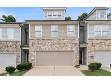 Charming townhome with a two-car garage, brick accents, and neutral siding in a well-maintained community at 382 Mulberry Se Row, Atlanta, GA 30354