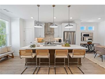 Bright kitchen boasts an island with seating, stainless steel appliances, and stylish pendant lighting at 626 Skytop Dr # 159, Cumming, GA 30040