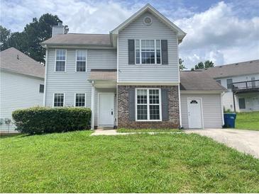 Traditional two-story home boasts a well-manicured lawn, brick accents, and classic window shutters at 5465 Twin Lakes Dr, College Park, GA 30349