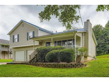 Charming two-story home featuring a welcoming front porch, a two-car garage, and a well-maintained lawn at 520 White Pines Dr, Dallas, GA 30157