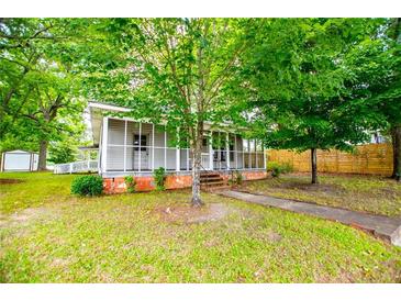 Charming single-story home with screened porch and lush front lawn, great curb appeal at 6539 E Strickland St, Douglasville, GA 30134