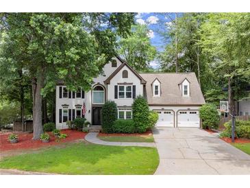 Charming two-story home with a well-manicured lawn, lush landscaping, and a two-car garage at 4300 May Apple Dr, Alpharetta, GA 30005