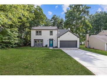Charming two-story home with a well-maintained lawn, a blue front door, and an attached garage at 1841 Surrey Hill Cir, Lawrenceville, GA 30044
