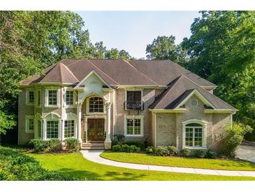 Stunning brick home with manicured lawn, arched entryway, and ample natural light with large windows at 1865 Mason Mill Rd, Decatur, GA 30033