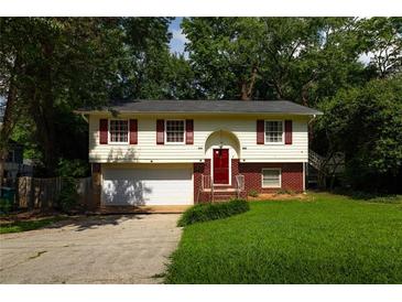 Charming two-story home with red shutters, a well-manicured lawn, and an attached garage at 2831 Carolyn Se Dr, Smyrna, GA 30080