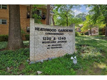 Sign for Heathwood Gardens Condominiums features vintage brick and landscaping at 1240 Woodland Ne Ave # 7, Atlanta, GA 30324