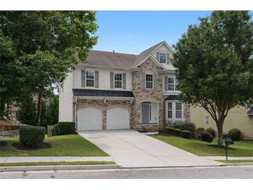 Charming two-story home featuring a stone facade, well-manicured lawn, and a two-car garage at 1722 Preserve Creek Way, Loganville, GA 30052