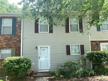 Charming townhome featuring a light exterior with dark shutters, complemented by well-maintained landscaping at 8957 Stonebridge Blvd, Douglasville, GA 30134