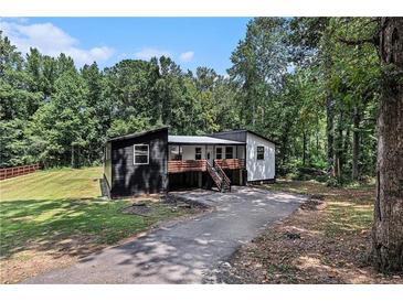 Unique home with a modern black and white exterior design nestled amongst mature trees at 140 Indian Lake Dr, Hiram, GA 30141