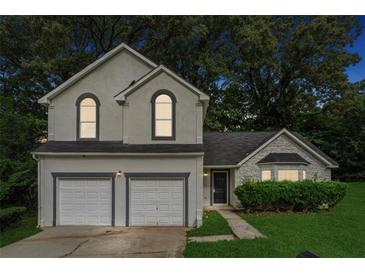 Charming two-story home with a two-car garage and beautifully landscaped front yard at 4464 Idlewood Park, Lithonia, GA 30038