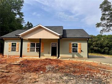 Charming single-story home features neutral siding, a welcoming front porch, and complementary shutters at 389 Campground School Rd, Dallas, GA 30157