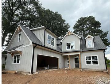 Charming two-story home with gray siding, an attached garage, and professionally landscaped yard at 99 Mountain Brook Dr, Cumming, GA 30041