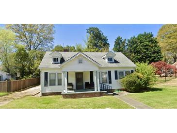 Charming home featuring a well-manicured lawn and a welcoming front porch perfect for relaxing outdoors at 8573 Campbellton St, Douglasville, GA 30134