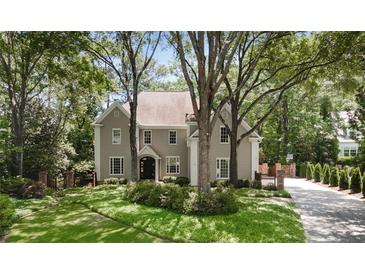 Charming two-story home with lush landscaping and mature trees providing shade and privacy at 2375 Hyde Park Nw Ct, Atlanta, GA 30318