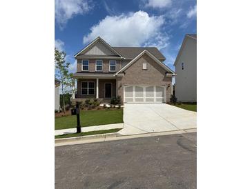 Beautiful brick two-story home featuring an attached two car garage, landscaping, and a well maintained lawn at 4266 Mulberry Pass Ct, Hoschton, GA 30548
