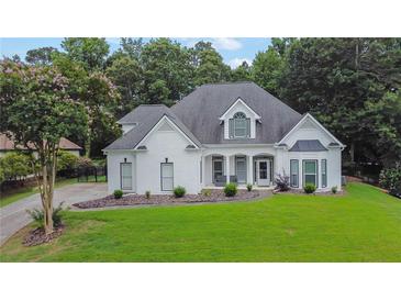Charming, single-story home with a manicured lawn and white painted brick at 2330 Wood Creek Ct, Dacula, GA 30019