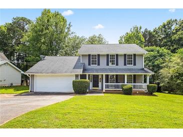 Charming two-story house with a well-manicured lawn and a welcoming front porch with white railings at 2431 Rosedale Creek Dr, Snellville, GA 30078