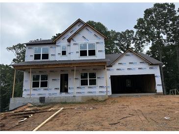 Two-story home under construction with visible framing and protective wraps, set against a wooded backdrop at 1115 Birch Way, Loganville, GA 30052