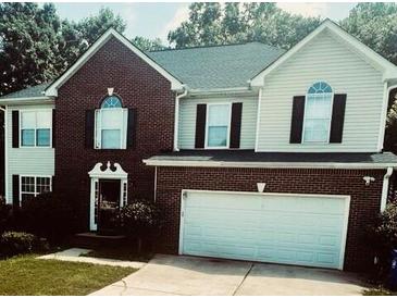 Charming two-story home with a brick and siding facade, attached two car garage, and manicured front lawn at 3233 Rockmill Dr, Ellenwood, GA 30294