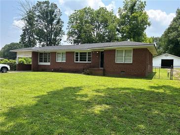 Charming brick home with a well-manicured lawn and mature trees at 3561 Clay Rd, Austell, GA 30106