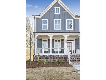 Charming two-story home with brick foundation, covered porch, and inviting curb appeal at 148 Palm St, Holly Springs, GA 30115