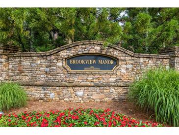 Stone monument sign for Brookview Manor with manicured flowerbeds and mature trees, marking the community entrance at 2403 Wistful Way, Marietta, GA 30066