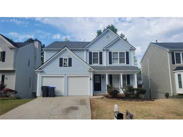 Charming light-blue two-story home with a two-car garage and manicured front yard at 3045 Binghampton Ln, Lawrenceville, GA 30044