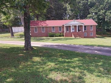 Charming brick home features a red roof, a columned front porch and a beautifully landscaped yard at 6005 Hendrix Rd, Cumming, GA 30040