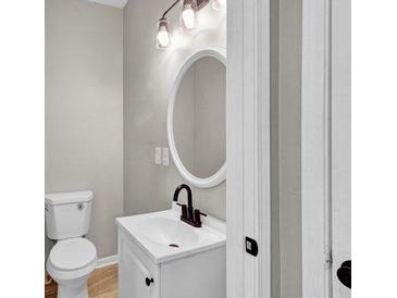 Charming bathroom featuring a white vanity, an oval mirror and modern lighting fixtures at 583 Whitaker St, Atlanta, GA 30318