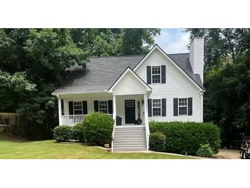 Charming white two-story home with a welcoming front porch and well-manicured landscaping at 6280 Autry Mill Rd, Cumming, GA 30028