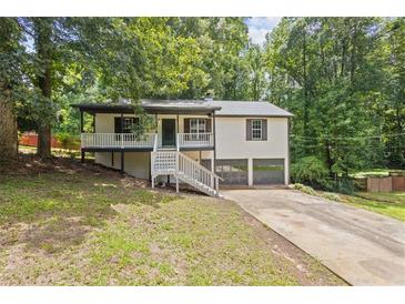 Charming home featuring a welcoming porch, two car garage and mature trees at 6441 Michell Way, Douglasville, GA 30135
