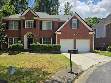 Charming two-story brick home featuring a well-manicured lawn and a two-car garage at 2670 Henderson Chase Ct, Tucker, GA 30084