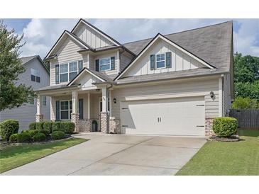 Charming two-story home featuring a two-car garage, manicured lawn and neutral color palette at 3940 Frasier Dr, Cumming, GA 30028