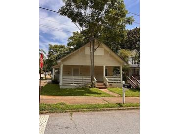 Traditional home featuring a covered front porch and well-maintained landscaping at 519 Roy Sw St, Atlanta, GA 30310
