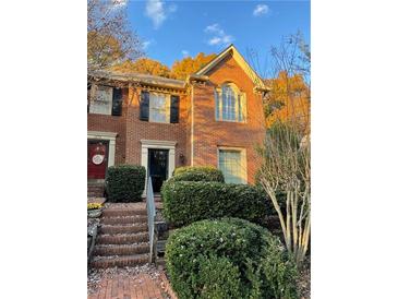 Charming brick townhome with manicured landscaping and symmetrical windows under a blue sky at 1271 Whitlock Ridge Sw Dr, Marietta, GA 30064