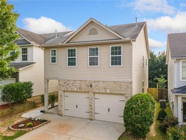 Charming two-story home with a brick-accented two-car garage and manicured front yard at 305 Hidden Creek Ln, Canton, GA 30114