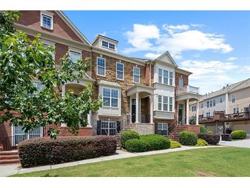 Charming townhome with a well-maintained lawn, manicured bushes, brick and stone facade, and inviting front entrance at 4874 Seldon Se Way, Smyrna, GA 30080