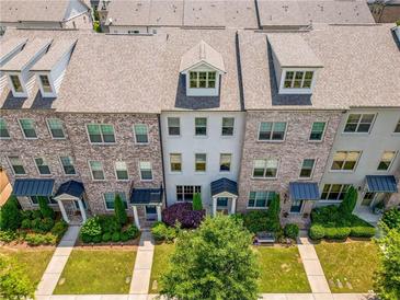 Charming brick townhomes with landscaped front yards and inviting entrances, showcasing a desirable community at 20057 Windalier Way, Roswell, GA 30076