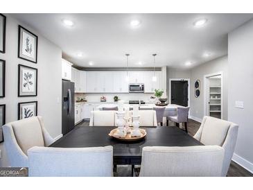Bright dining area showcases a table setting with a view to the modern kitchen and white cabinetry at 3351 Orwell Way # 2301, Cumming, GA 30041