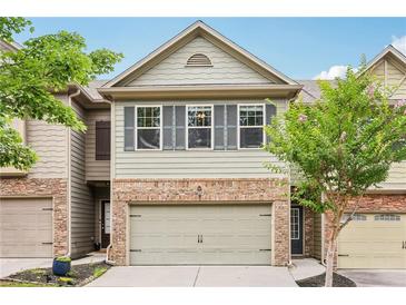 Charming townhome with a two-car garage and well-manicured landscaping at 146 Sunset Ln, Woodstock, GA 30189