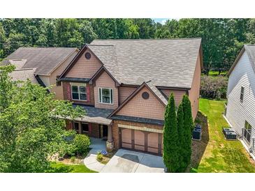 Charming two-story home featuring cedar-shake siding, a brick-accented garage, and a well-manicured front lawn at 2532 Gloster Mill Drive Southwest, Lawrenceville, GA 30044