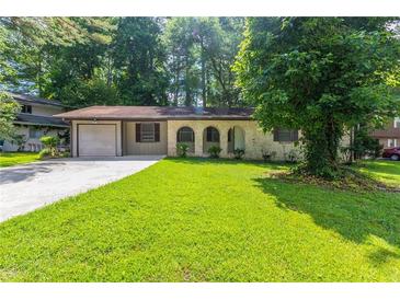 Charming single-story home with a well-maintained front yard and a driveway leading to an attached garage at 1105 Buckhurst Dr, Atlanta, GA 30349